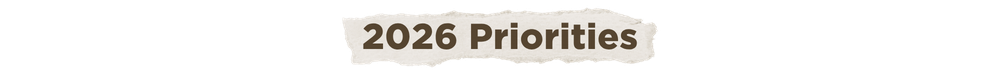 A torn piece of paper with brown text reads, "2026 Priorities."
